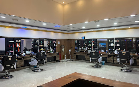 Razor King actual interior: cream walls, gold ceiling trim, dark wood stations and black chrome barber chairs